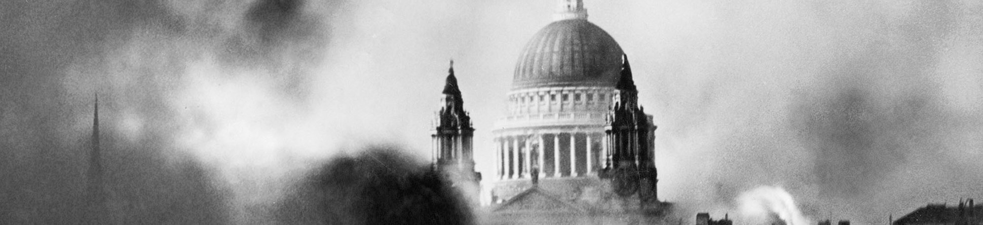 The dome of St Paul's emerging out of a cloud of smoke that engulfs burning buildings in the foreground.