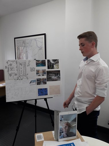 Man standing next to display board making a presentation