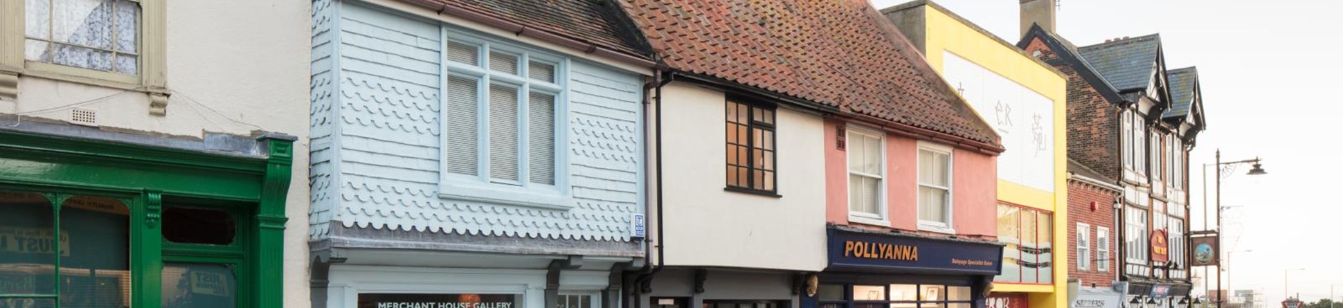 Colourful shop fronts on a quiet high street.