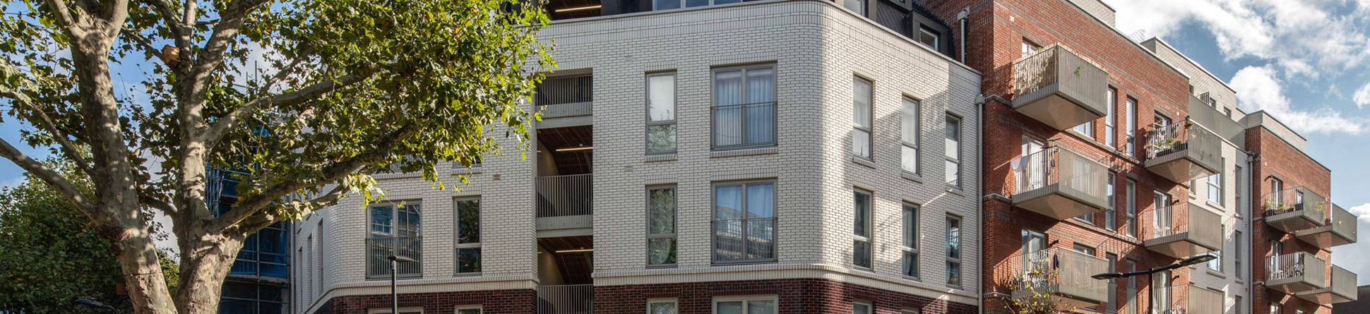 An exterior view of low-rise hosing blocks at a small London estate.