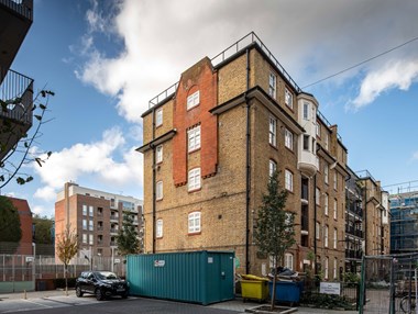 A view of redeveloped urban housing with an older block in the foreground.