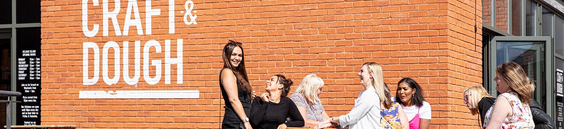 Customers enjoying the sunshine at Craft and Dough at 1a Kelham Square in Sheffield's Kelham Island, Sheffield. The conservation area has been rescued and removed from the Heritage at Risk Register in 2019.