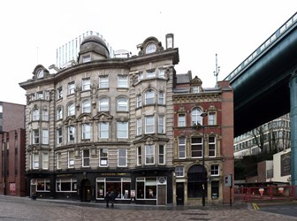 Exterior view of Akenside House in Newcastle, UK next to a blue overpass structure