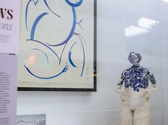 Model of a person kneeling on a plinth and an abstract drawing